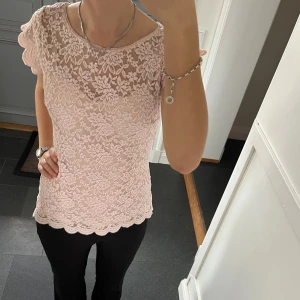 Rosa spetstopp  - Rosa kortärmad tröja i spets från Orsay i fint skick. Kan inte hitta storlek men skulle säga S, passar även M. Fastsytt tyg på insidan. Använd gärna köp nu!