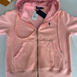 Rosa hoodie från Polo Ralph Lauren - Snygg ljusrosa hoodie från Polo Ralph Lauren, i storlek S