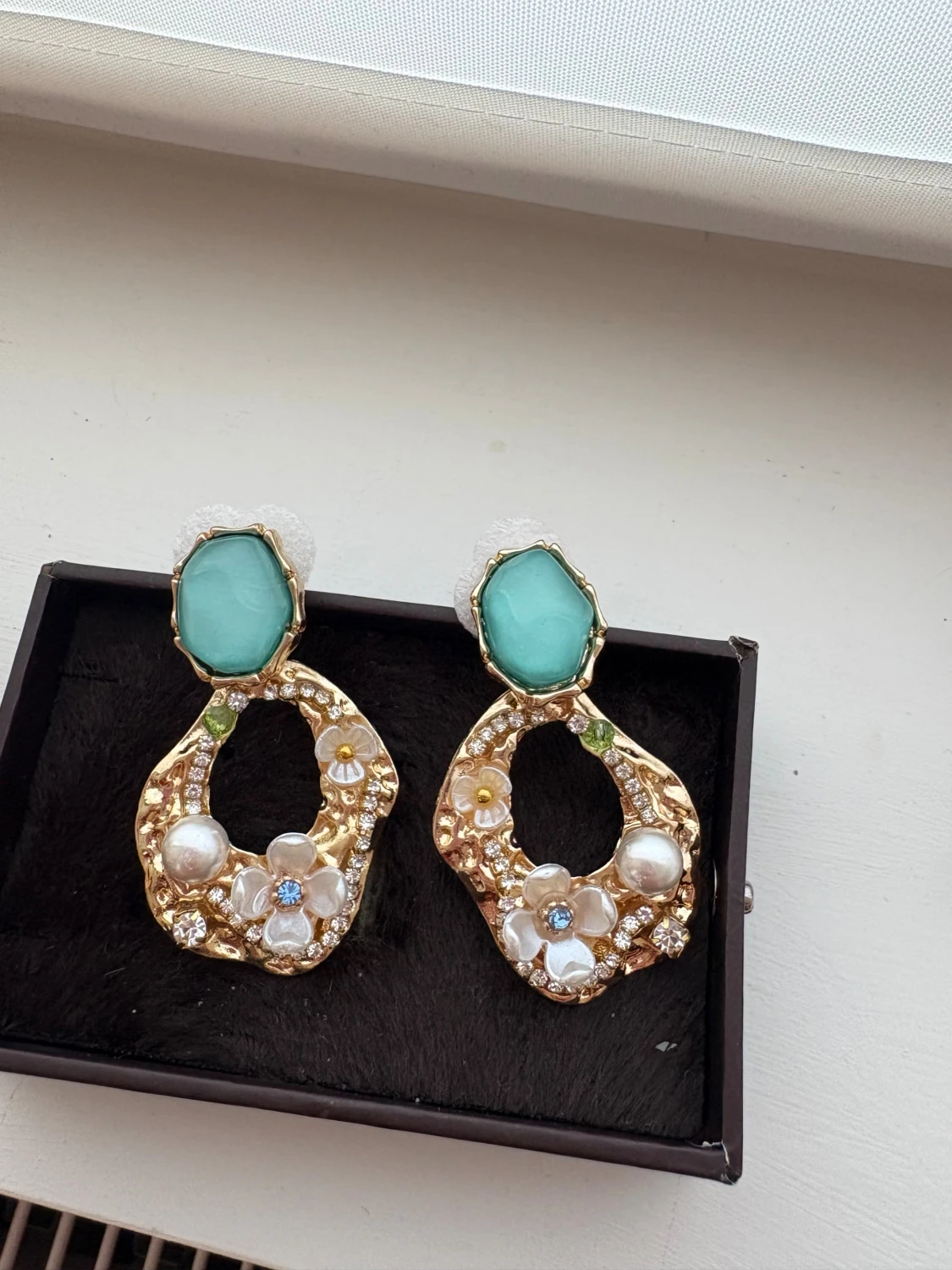 Guldiga örhängen med blommor och pärlor