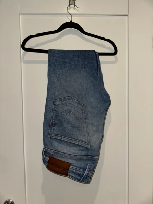 Replay jeans blå tapered 32/30 - Riktigt schyssta replay ANBASS. De är något äldre och därför har de den mer vintage looken. De har den klassiska fem ficks designen med en snygg replay läderpatch baktill. Jeansen har en tapered passform och är tillverkade i slitstarkt denimtyg. Perfekt för dig som gillar en modern och avslappnad stil.
