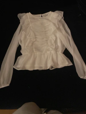 Vit volang blus - Fin blus med volanger från Lindex. Passar till festliga tillfällen och till dig som gillar lite mer stil rena looks.