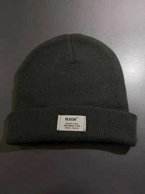 Superskön mjuk olivgrön mössa  - Superskön mjuk olivgrön mössa från märket Reason. Finstickad i syntetmaterial med uppvikt kant. Varm och jätteskön! Passar M/L. Mycket bra skick, som ny! 