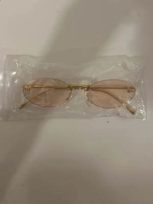Nya oanvända solglasögon – guldig oval modell - Helt nya och oanvända solglasögon. Guldig metallram med oval form och lätt tonade glas. Levereras i originalpåse. Snygga och trendiga – passar till många outfits.😍😍❤️❤️