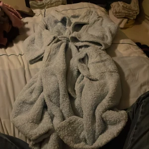 Ljusblå morgonrock  med krage - Mysig ljusblå morgonrock från  primers butterfly i mjukt frottématerial. Den  har en bred krage, praktiska fickor och ett bälte i midjan för att enkelt kunna justera passformen. Perfekt för chilliga dagar när du vill ha något extra skönt på dig inomhus.3/4 ärm.