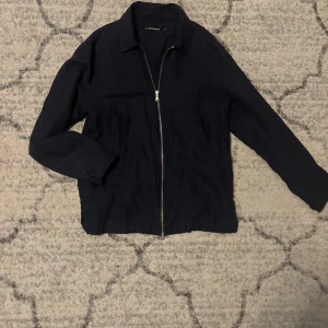 J.Lindberg (overshirt tröja) - Exklusiv J.Lindeberg overshirt i stilren design, storlek M. Kan bäras både som skjorta och lätt jacka. Hög kvalitet med en modern och tidlös look, perfekt för både vardag och finare tillfällen. Sällsynt vara i mycket fint skick. Nypris 1700