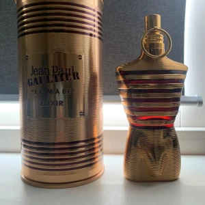 Jean Paul Gaultier Le Male Elixir ca 115 ml - Säljer en ikonisk Jean Paul Gaultier Le Male Elixir parfym, 125ml. Flaskan har en cool guldfärgad kropp med röda och svarta detaljer, formad som en torso. Kommer med original metallförpackning i guld med svarta ränder. Perfekt för dig som gillar lyxig design och starka dofter.