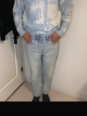 Levi's 501 ljusa jeans - Säljer ett par klassiska Levi's 501 jeans i ljusblå tvätt. De har rak passform, fem fickor och knappgylf. Jeansen är tillverkade i slitstark bomull och har en tidlös look som funkar till många stilar. Perfekt för dig som gillar vintage-vibe.