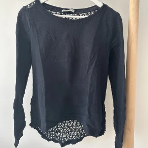 Långärmad topp med spets från Abercrombie - Blå långärmad topp från Abercrombie & Fitch med snygga virkade detaljer på ryggen. Rund halsringning och mjukt bomullsmaterial framtill.