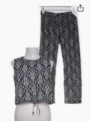 Svart och vit mönstrad kostymset - Tvådelat kostymset med croppad topp och raka byxor i svart och vitt med ett snyggt rutig mönster. 