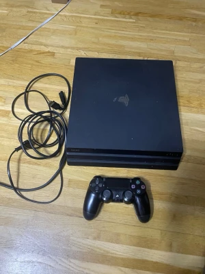 PlayStation 4 Pro - Sony PlayStation 4 Pro med original DualShock 4-kontroll och strömkabel samt HDMI-kabel. Konsolen har några ytliga repor och märken men är i gott skick och fungerar utmärkt för spel. Perfekt för dig som vill ha kraftfull prestanda och 4K-stöd.