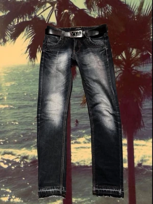 Mörkblå fadeade jeans, storlek 30 - Snygga mörkblå jeans från just boy storlek 30 med coola slitningar och ljusa tvättade partier. Klassisk femficksmodell, kontrastsömmar och rå kant vid benslut. Jeansen har normal passform och är tillverkade i jeansmaterial. Bälte medföljer.