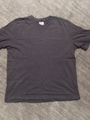 Mörkgrå T-Shirt  - Säljer denna oanvända mörkgråa T-Shirten i 100 % bomull, som tyvärr inte kommer till användning. 