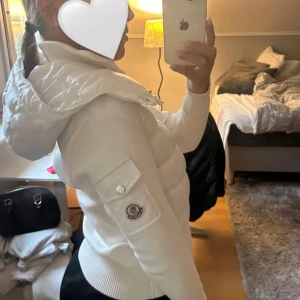 Vit puffer kardigan jacka från Moncler med huva  XXS  - Säljer en snygg vit puffer kardigan jacka från Moncler med stickade ärmar och stor huva. Jackan har dragkedja framtill, fickor med knappar och Moncler-logga på ärmen. Perfekt för dig som vill ha en clean och stilren look med premiumkänsla.