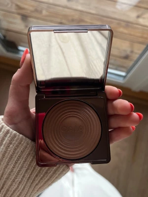 CAIA Glow Bronzer i brun nyans - Säljer en CAIA Glow Bronzer med spegel i locket.  Fick i julklapp men ej kommer använda då jag har andra. HELT oanvänd bara öppnad. Färgen La Digue, nypris (395kr)