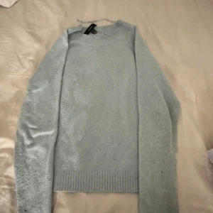 Ljusblå stickad tröja från Vero Moda - Mysig ljusblå stickad tröja från Vero Moda i storlek XS. Tröjan har rund halsringning, ribbade muddar och lång ärm. Perfekt för lager-på-lager och chill dagar. Enkel och stilren design som funkar till det mesta.