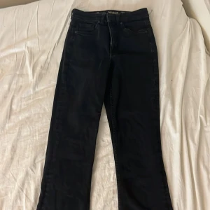 Svarta bootcut jeans  - Svarta jeans med bootcut passform och klassisk femficksdesign. Jeansen har hög midja och är tillverkade i ett jeansmaterial. Perfekta för dig som gillar en tidlös och snygg look med lite utsvängda ben.