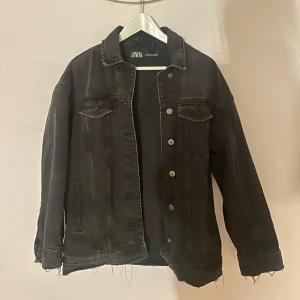 Jeansjacka  - Svart/mörk grå jeansjacka från Zara i oversized modell med slitna kanter och klassisk krage. Jackan har knappar framtill, två bröstfickor och långa ärmar💕💕