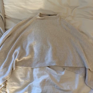 Beige poncho från Gina Tricot - Säljer en beige poncho från Gina Tricot i mjukt stickat material. Aldrig använd, at xs/s 