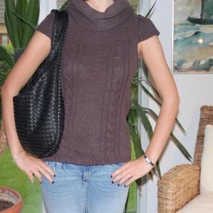 Brun stickad tröja - Mysig kortärmad turtelneck tröja. Passar jättebra nu till hösten. Det står ingen storlek i tröjan, men vi skulle säga att det är en storlek s.