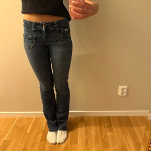 Blå bootcut jeans med låg midja - Snygga blå jeans med bootcut och låg midja. Jeansen har klassiska fem fickor, dubbla knappar i midjan och smal passform upptill som går ut lite vid benslutet. Jeansen är ifrån only och står ingen storlek på de men jag är 170 och har storlek 25-27 och 32-34 och xs-s för referens💓