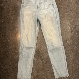 Hollister ljusblå  jeans  - Ljusblåa  jeans från Hollister med hög midja och raka ben. Jeansen har råa, avklippta benslut och klassisk femficksdesign. Storlek W24 L27