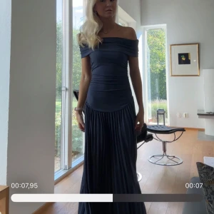 Bal/Aftonklänning slutsåld  - Elegant mörkblå långklänning med offshoulder-design och plisserad kjol. Perfekt för en bal eller fin tillställning. Enbart använd en gång (nyskick) pris går att diskuteras