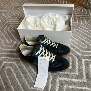 Mörkblå Margiela Gats med KVITTO✅ - Säljer dessa feta mörkblåa gatsen i storlek 43. Originella skokartongen, dustbagsen och kvittot tillkommer i köp. De är i ett väldigt bra skick och har inga defekter. Priset kan diskuteras och skriv gärna vid funderingar :)