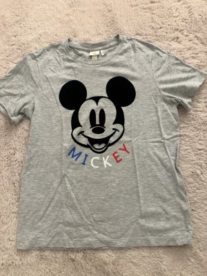 T-shirt - mickey mouse/musse pigg - Bekväm mickey mouse/musse pigg t-shirt som aldrig är använd (nyskick)  Den är lite skrynklig på bild då den legat vikt i garderoben - men kan stryka den innan jag fraktar  Köpt från h&m