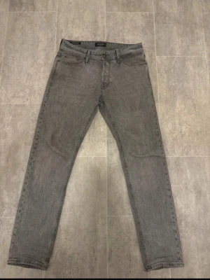 Gråa Jack & Jones jeans  - Grå Jack & Jones jeans i fint skick. Sparsamt använda, inga hål eller fläckar. Bekväma och stilrena.