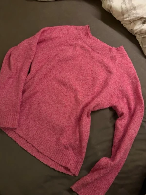 Rosa stickad tröja från Vero Moda - Mysig rosa stickad tröja från Vero Moda i storlek XS. Tröjan har en enkel design med ribbade muddar vid hals, ärmslut och nederkant. Perfekt för att hålla sig varm under kyliga dagar och passar till jeans eller kjol. Lite nopprig men annars i jättefint skick! 