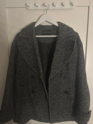 Svartvit skepparkavaj från Ellos - Säljer en svartvit skepparkavaj från Ellos i storlek 38. Jackan har dubbelknäppning med svarta knappar, bred krage och ett snyggt rutig mönster. Materialet är ullblandning som känns både mjukt och rejält. Köpt nu i höst för ca 899 kr. Kan tänka mig sälja för 349 vid snabb affär. Inga defekter🥰