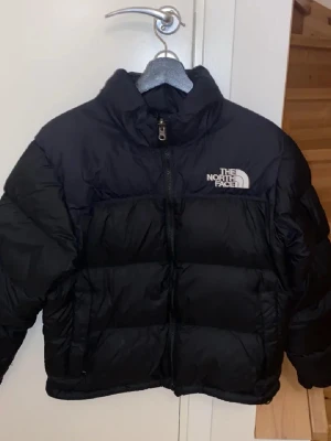  The North Face jacka - Säljer en svart pufferjacka från The North Face i storlek M. North face jackan retro nuptse, bra skick      höstjacka, vintage, cubus, vintagekläder, skjorta, studentklänning, jeans, jackor, vårjacka, sommarjacka, blus, H&M, y2k, kjol, långkjol, långklänning, sommar, blå, svart, rosa, elegant, elegant blus, stor väska, liten väska, randig, läder, läderjacka, boots, klackar, fest, festblus, jane norman, debenhams, bomberjacka, vintage, nakd, blus, trenchcoat