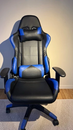 Gamingstol  - Bekväm gamingstol i svart och blått. Justerbar höjd och armstöd. Skön att sitta i både vid gaming och plugg/arbete. 