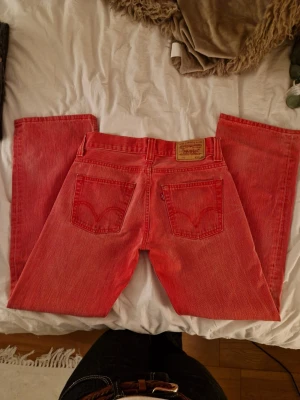 Levi's 512  - Säljer ett par Levi's 512 bootcut jeans i en cool röd färg. Tycker inte storleken stämmer, tycker själv att de sitter som storlek W27 ungefär!