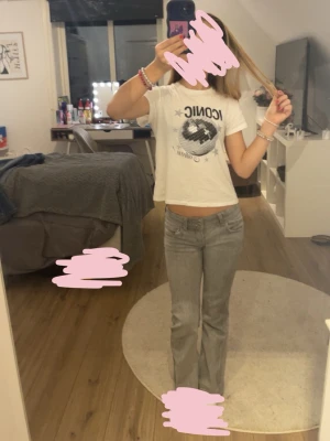 Grå bootcut jeans med låg midja - Säljer ett par gråa jeans med bootcut-snitt och låg midja. Jeansen har klassisk femficksdesign och är tillverkade i ett mjukt jeanstyg som sitter snyggt på benen. Perfekta för dig som gillar retrovibbar och vill ha en cool look.