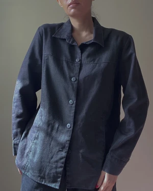 Vintage Black Linen Boxy Top - Vintage black Linen Women's boxy shirt. Black Buttons with Collared Shirt. Side pockets. Excellent Condition. Best worn oversized. Model is 160cm (5”3) and generally fits S/M.  65 CM/ 25.6 IN Length 59 CM/ 23.2 IN Sleeve 46 CM/ 18.1 IN Shoulders 106 CM/ 41.7 IN Chest 104 CM/ 40.9 IN Waist