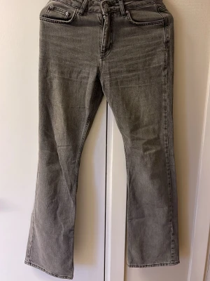 Grå bootcut jeans - Säljer ett par gråa bootcut jeans med klassisk femficksdesign och dragkedjegylf. Jeansen har en snygg tvättad look och raka ben som går ut lite nedtill. Perfekta till sneakers eller boots för en avslappnad vibe.