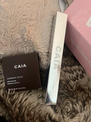 CAIA Luminous Touch Glow Bronzer & F10 Borste - Säljer CAIA Luminous Touch glow bronzer i färgen La Digue. Medföljer även CAIA F10 sminkborste i en silvrig färg. Helt ny förpackning, köptes i början av december men säljs pga fel färg. Aldrig använd. 