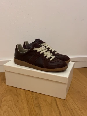 Maison Margiela bruna sneakers - Maison Margiela sneakers i mörkbrunt skinn och mocka.