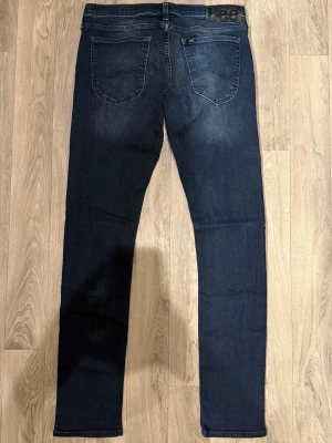 Lee Luke Jeans Mörkblå W31 L34  - Mörkblåa Lee Luke Jeans i mycket fint skick i storlek W31/L34. Mått - Midja: 42cm, Benlängd: 108. Modellen är 185cm & 63kg. Hör av dig vid funderingar!🤩