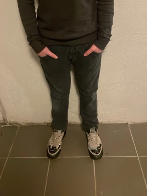 Svarta Dondup jeans - Säljer ett par svarta Dondup jeans med klassisk femficksdesign och snygga detaljer vid fickorna. Jeansen har en slim passform och är tillverkade i mjukt bomullsmaterial med lite stretch för extra komfort. Perfekt för dig som gillar stilrena och bekväma jeans.