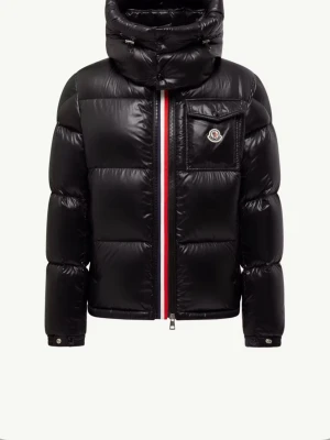 Svart pufferjacka från Moncler - Svart pufferjacka från Moncler med glansig finish, hög krage och huva. Jackan har en röd, vit och blå rand vid dragkedjan, Moncler-logga på bröstfickan och flera praktiska fickor. Materialet är polyester och dun, perfekt för kalla dagar.