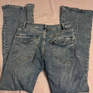 Bootcut jeans - Blåa jeans från Kappahl i storlek 170 och modell Freja. Jeansen har en söm detalj längsbenen och är Bootcut och är midwaist.