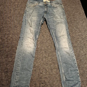 Replay MickyM Slim Tapered Jeans 31 - Snygga ljusblå jeans från Replay, modell MickyM med slim tapered fit. Klassisk femficksdesign, slitna detaljer och snyggt Replay-läderpatch bak. Jeansen har smal passform som smalnar av mot ankeln och är tillverkade i mjukt jeanstyg.