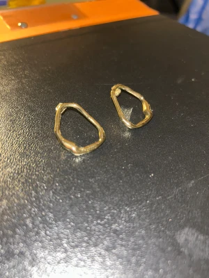 Guldiga oregelbundna örhängen - Unika örhängen i 14K guldplatering med organisk form. Helt oanvända utan prislapp. De har en modern och minimalistisk vibe, perfekta för dig som gillar att sticka ut med detaljer. Säljs som ett par och passar till alla tillfällen när du vill addera lite till din stil. 