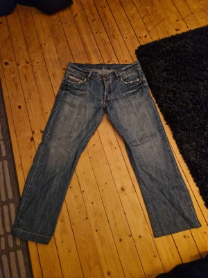 Blå Replay jeans med slitningar - Sköna diesel jeans med slitningar, en defekt över knät, de är lagade där