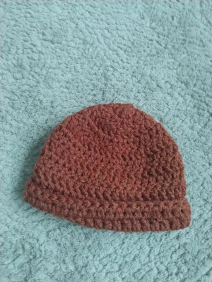 Handgjord virkad brun mössa  - Säljer en virkad mössa i varm brun färg som jag gjort själv. Mössan har en chunky look med uppvikt kant. Passar dig som vill sticka ut lite extra i höst och vinter.