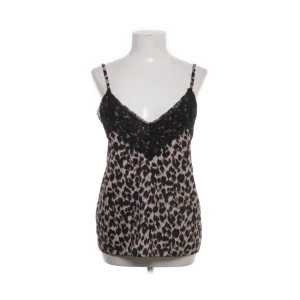 Leopardmönstrad linnetopp från Boohoo - Säljer en snygg leopardmönstrad linnetopp från Boohoo med tunna axelband och spetsdetalj upptill. Toppen har en beige och svart färgkombination och är perfekt för dig som vill sticka ut. Materialet känns lätt och luftigt.