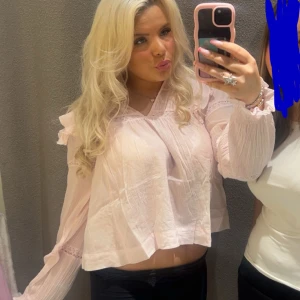 Ljusrosa blus med volangdetaljer - Säljer en ljusrosa blus med volangdetaljer på axlarna och ärmarna. Den är i storlek 170