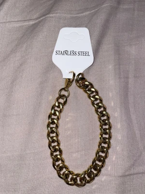 Guldfärgat armband - Lyft din stil med ett elegant guldfärgat armband med en tydlig och modern bredd på 11 mm. Med en längd på 21 cm sitter det bekvämt runt handleden och ger ett kraftfullt men stilrent intryck. Den glänsande guldfärgade finishen tillför en lyxig känsla som passar lika bra till vardags som vid festliga tillfällen – ett perfekt armband för dig som vill kombinera trend och attityd.🪄